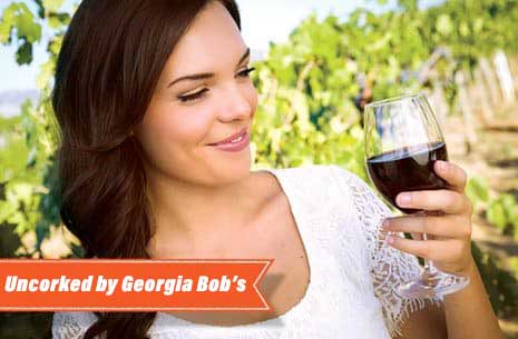 Woman looking at a glass of red wine at Georgia Bob’s Uncorked in Byron Georgia
